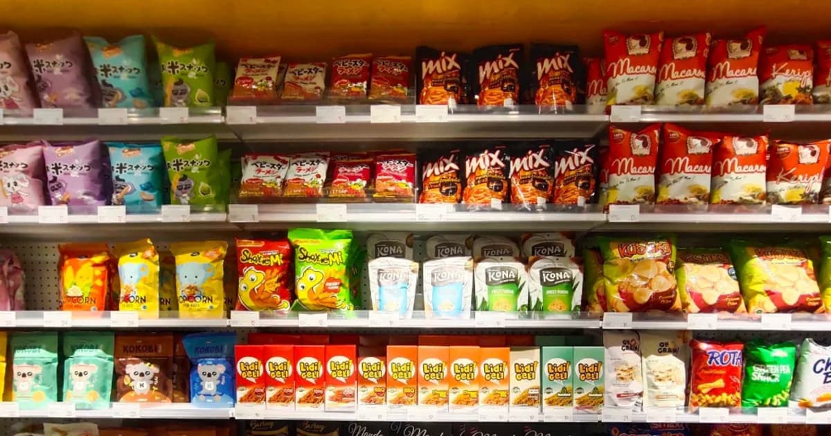 Rayon de confiseries et de snacks industriels en supermarché, illustrant l'omniprésence du sucre